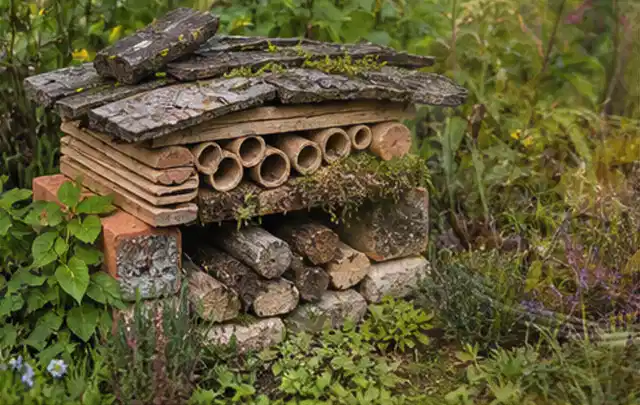 Naturnaher Unterschlupf aus Holz Rinde und Pflanzenstängeln im Garten; Thema WPC Sichtschutz, Schwerpunkt Planung; Ergebnis.
